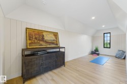 Workout room with vaulted ceiling, light wood-style floors, recessed lighting, and wood walls - 