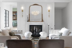 Living room featuring a premium fireplace, a chandelier, and wood finished floors - 