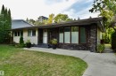 View of front of house with stone siding and a front lawn - 13910 101A Avenue, Edmonton, AB  - Outdoor With Facade 