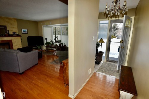 Hall with light wood-style flooring, a chandelier, and a textured ceiling - 13910 101A Avenue, Edmonton, AB - Indoor