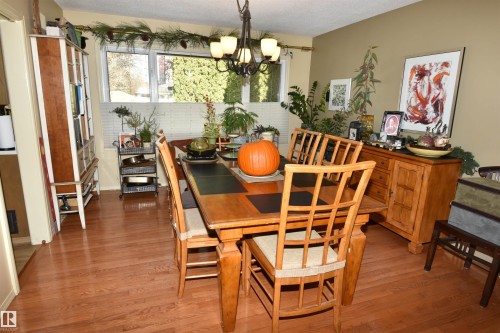 Dining area featuring light wood finished floors, a chandelier, and a textured ceiling - 13910 101A Avenue, Edmonton, AB - Indoor Photo Showing Dining Room