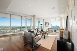 Living area with dark wood-type flooring, a view of skyline, and recessed lighting - 