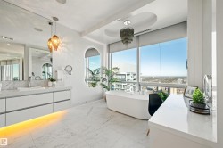 Full bathroom featuring vanity, a freestanding bath, and light marble finish flooring - 