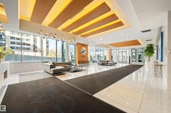 Building lobby with floor to ceiling windows and recessed lighting - 
