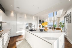 Kitchen featuring modern cabinets, white cabinets, recessed lighting, a large island, and light stone counters - 
