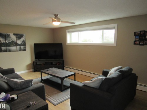 Living room with baseboard heating, light wood-style flooring, and a ceiling fan - 5016 51 Street, Barrhead, AB - Indoor Photo Showing Living Room