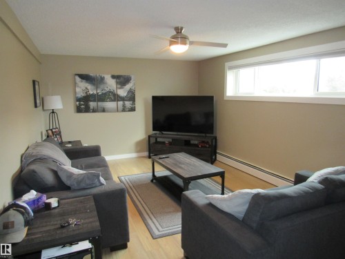 Living area featuring a baseboard radiator, light wood-style flooring, and a ceiling fan - 5016 51 Street, Barrhead, AB - Indoor Photo Showing Living Room