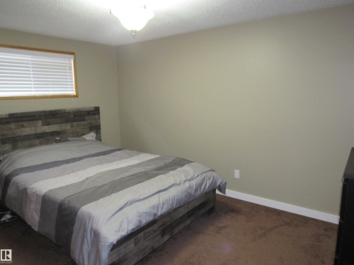 Bedroom featuring dark colored carpet and a textured ceiling - 5016 51 Street, Barrhead, AB - Indoor Photo Showing Bedroom