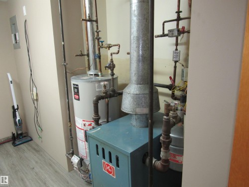 Utility room with gas water heater and a heating unit - 5016 51 Street, Barrhead, AB - Indoor Photo Showing Basement