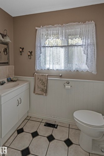 Bathroom featuring vanity, a wainscoted wall, and light tile patterned flooring - 218 58532 Range Road 113, Rural St. Paul County, AB - Indoor Photo Showing Bathroom