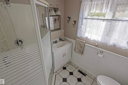 Bathroom with a shower stall, vanity, light tile patterned floors, and wainscoting - 218 58532 Range Road 113, Rural St. Paul County, AB - Indoor Photo Showing Bathroom