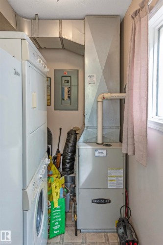 Utilities with stacked washing machine and dryer, electric panel, and heating unit - 218 58532 Range Road 113, Rural St. Paul County, AB - Indoor Photo Showing Laundry Room