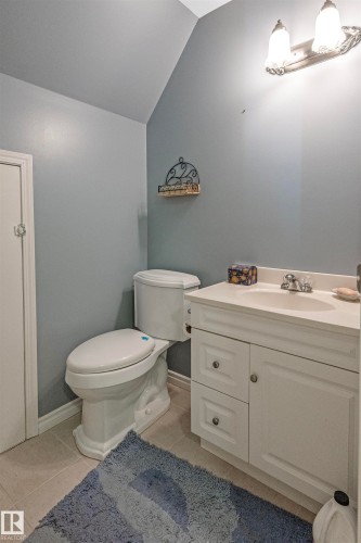 Up stairs bathroom featuring vanity, light tile patterned flooring, and lofted ceiling - 218 58532 Range Road 113, Rural St. Paul County, AB - Indoor Photo Showing Bathroom