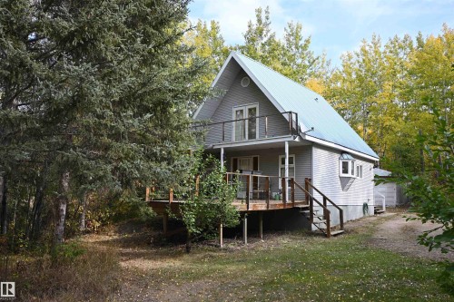 Rear view of house with a metal roof and a porch - 218 58532 Range Road 113, Rural St. Paul County, AB - Outdoor With Balcony