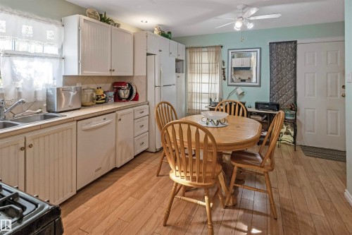 Kitchen with tile counters, tasteful backsplash, white appliances, ceiling fan, and light wood-type flooring - 218 58532 Range Road 113, Rural St. Paul County, AB - Indoor