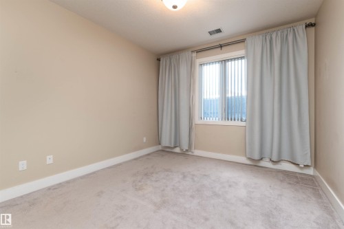 Carpeted empty room with baseboards - 140 6079 Maynard Way, Edmonton, AB - Indoor Photo Showing Other Room
