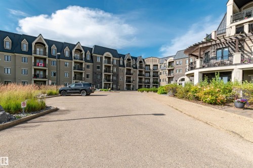 View of building exterior featuring uncovered parking - 140 6079 Maynard Way, Edmonton, AB - Outdoor With Facade