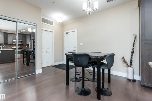 Dining area featuring dark wood finished floors - 140 6079 Maynard Way, Edmonton, AB - Indoor Photo Showing Dining Room