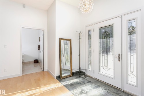 Entryway featuring light wood-type flooring, a chandelier, and a high ceiling - 19103 Ellerslie Road Sw, Edmonton, AB - Indoor Photo Showing Other Room