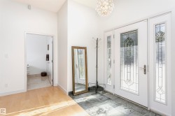 Entryway featuring light wood-type flooring, a chandelier, and a high ceiling - 