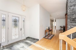 Foyer featuring a chandelier, wood finished floors, and stairway - 