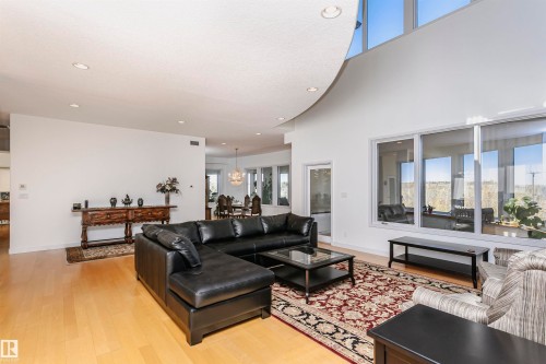 Living area with healthy amount of natural light, recessed lighting, light wood-style flooring, a towering ceiling, and a chandelier - 19103 Ellerslie Road Sw, Edmonton, AB - Indoor Photo Showing Living Room