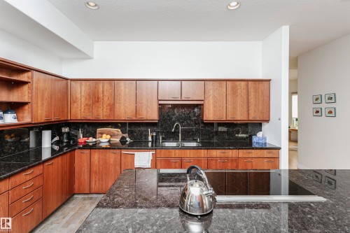 Kitchen with tasteful backsplash, brown cabinetry, open shelves, and recessed lighting - 19103 Ellerslie Road Sw, Edmonton, AB - Indoor Photo Showing Kitchen With Double Sink