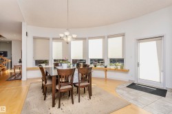 Dining area featuring stairs, light wood finished floors, and a chandelier - 