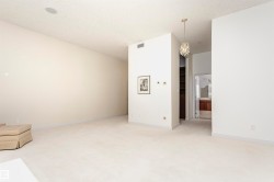 Unfurnished room with a chandelier, light carpet, and a textured ceiling - 