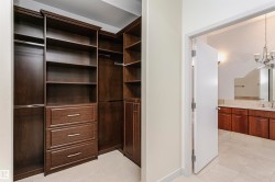 Walk in closet featuring a chandelier and light tile patterned floors - 