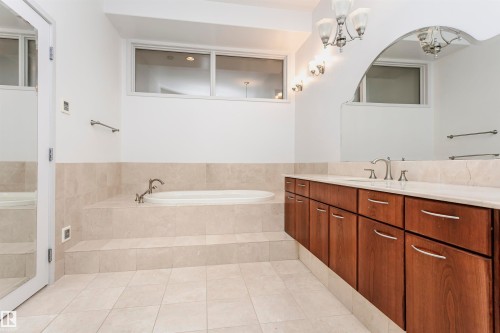 Bathroom featuring vanity, a bath, light tile patterned floors, and a chandelier - 19103 Ellerslie Road Sw, Edmonton, AB - Indoor Photo Showing Bathroom