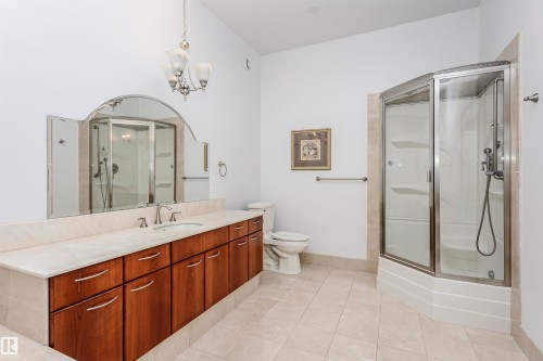 Bathroom with light tile patterned floors, a shower stall, vanity, and a chandelier - 19103 Ellerslie Road Sw, Edmonton, AB - Indoor Photo Showing Bathroom