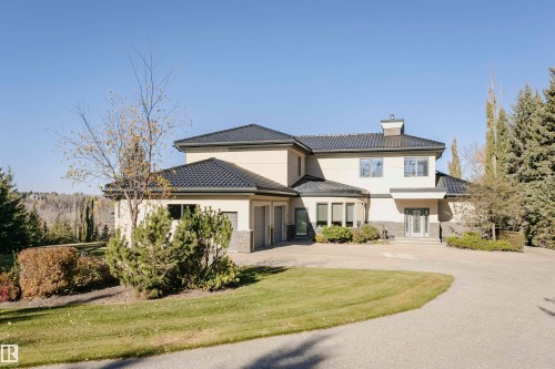 View of front of home with stone siding, stucco siding, a chimney, driveway, and a garage - 19103 Ellerslie Road Sw, Edmonton, AB - Outdoor