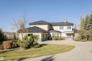 View of front of home with stone siding, stucco siding, a chimney, driveway, and a garage - 19103 Ellerslie Road Sw, Edmonton, AB  - Outdoor 