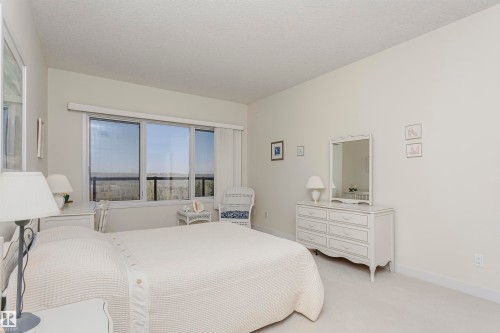 Carpeted bedroom with baseboards and a textured ceiling - 19103 Ellerslie Road Sw, Edmonton, AB - Indoor Photo Showing Bedroom