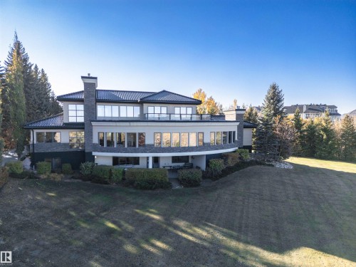 Back of house featuring a chimney, a balcony, a yard, and stucco siding - 19103 Ellerslie Road Sw, Edmonton, AB - Outdoor With Deck Patio Veranda