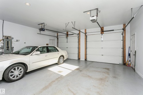 Garage with electric panel and a garage door opener - 19103 Ellerslie Road Sw, Edmonton, AB - Indoor Photo Showing Garage