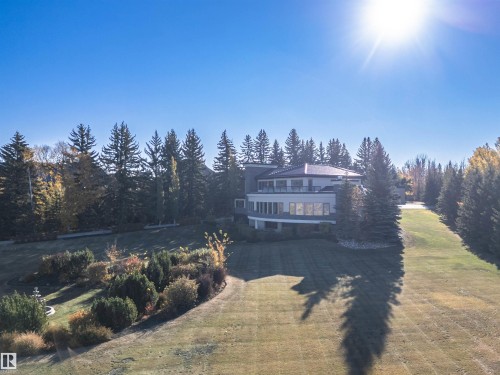 Rear view of house with a yard, a balcony, and a view of trees - 19103 Ellerslie Road Sw, Edmonton, AB - Outdoor With View