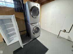 Laundry room with concrete floors and stacked washing machine and dryer - 