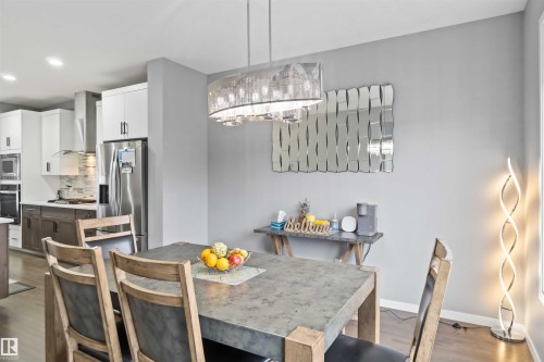 Dining area with dark wood-style flooring, recessed lighting, and a chandelier - 17816 59 Street, Edmonton, AB - Indoor Photo Showing Dining Room