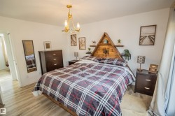 Bedroom featuring wood finished floors and a chandelier - 