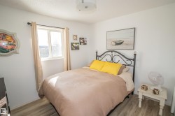Bedroom featuring wood finished floors and a textured ceiling - 