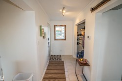 Corridor with crown molding, a barn door, and light tile patterned flooring - 