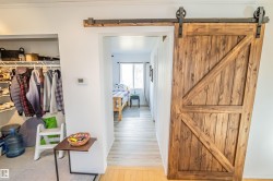 Hall featuring light wood finished floors and a barn door - 