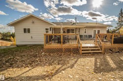 Rear view of property featuring a deck and a shingled roof - 
