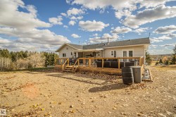 Rear view of house with a deck and roof with shingles - 