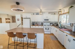 Kitchen with white cabinetry, tasteful backsplash, white appliances, and pendant lighting - 