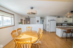 Dining room with light wood-style floors and wood walls - 