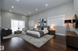 This expansive room features dark hardwood flooring, recessed lighting, and large windows with blinds - 