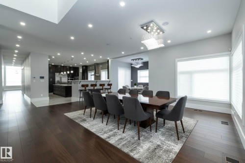 Spacious open-concept living area featuring dark hardwood floors, recessed lighting, and large windows providing natural light - 14 3466 Keswick Boulevard, Edmonton, AB - Indoor Photo Showing Dining Room
